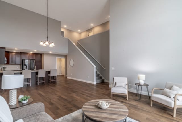 642 Haeberle Ave, New Ulm, MN 56073 - living room featuring stairs, wood finished floors, a chandelier, recessed lighting, and a towering ceiling