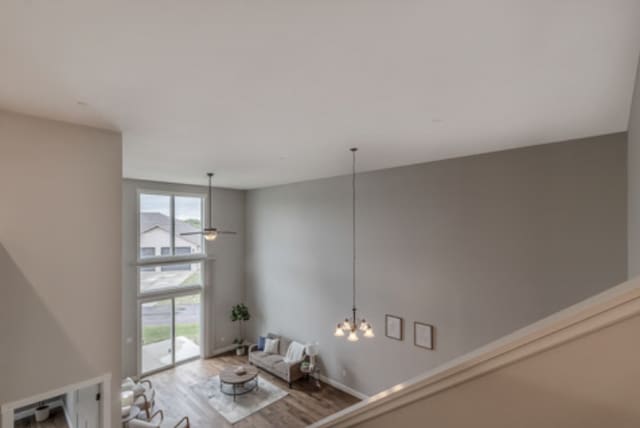 642 Haeberle Ave, New Ulm, MN 56073 - unfurnished living room with healthy amount of natural light, wood finished floors, and a chandelier