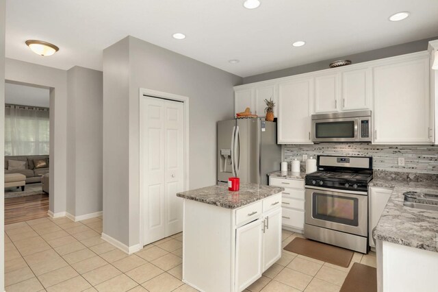 12049 Waconia Cir NE, Blaine, MN 55449 - kitchen with stainless steel appliances, tasteful backsplash, white cabinetry, light tile patterned floors, and a center island
