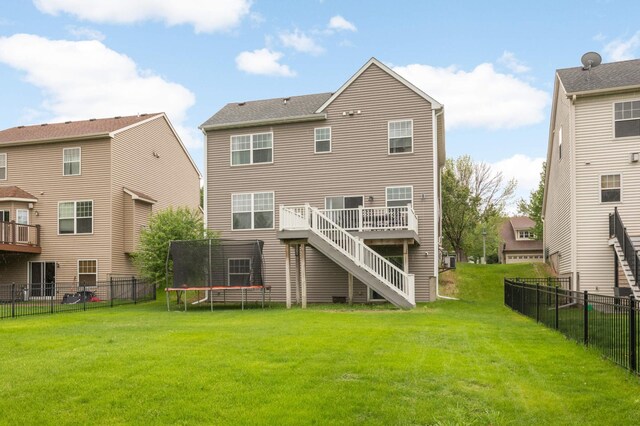 12049 Waconia Cir NE, Blaine, MN 55449 - back of house with a trampoline, stairway, and a wooden deck