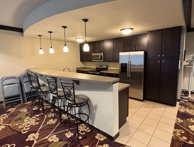 601 Levander Way Unit 311, South Saint Paul, MN 55075 - kitchen with stainless steel appliances, a kitchen bar, a peninsula, hanging light fixtures, and light tile patterned floors