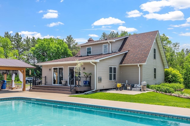 11520 120th St N, Stillwater, MN 55082 - rear view of house with a deck, a patio, an outdoor pool, a lawn, and a chimney