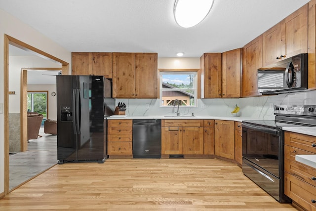 11520 120th St N, Stillwater, MN 55082 - kitchen with black appliances, a sink, light wood finished floors, light countertops, and brown cabinets