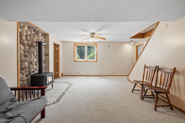 11520 120th St N, Stillwater, MN 55082 - sitting room featuring light colored carpet, a wood stove, a ceiling fan, a textured ceiling, and baseboards