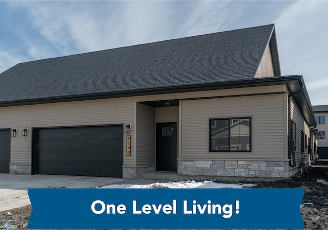 4150 Arthur Dr, Fargo, ND 58104 - view of front of house with stone siding, an attached garage, and a shingled roof