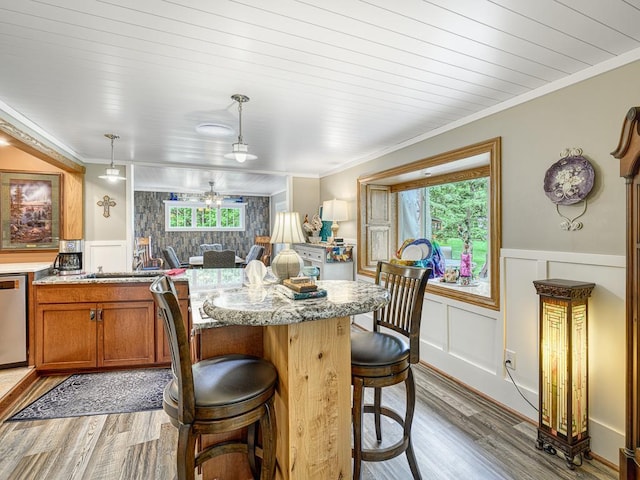 1144 Waldon Pl, Arden Hills, MN 55112 - kitchen with light wood-type flooring, a decorative wall, a wainscoted wall, a breakfast bar, and brown cabinets