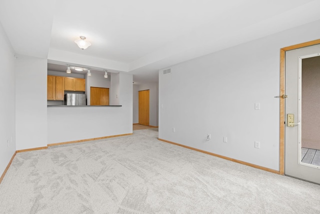 560 2nd St Unit 408, Minneapolis, MN 55401 - unfurnished living room with light carpet, baseboards, and track lighting