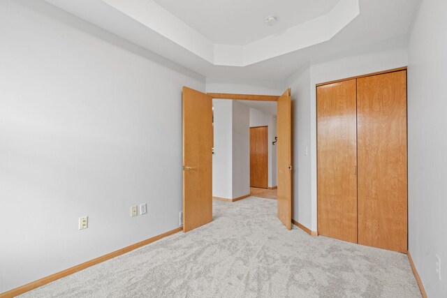560 2nd St Unit 408, Minneapolis, MN 55401 - unfurnished bedroom with carpet, a closet, baseboards, and a raised ceiling