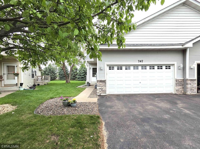 747 Park Brook Rd NW, Isanti, MN 55040 - view of front facade with stone siding, asphalt driveway, a garage, and a front lawn