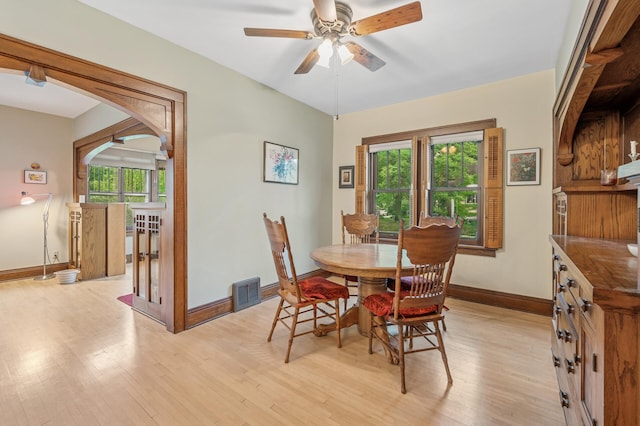 1441 Simpson St, Saint Paul, MN 55108 - dining room with light wood-style flooring, a ceiling fan, and arched walkways