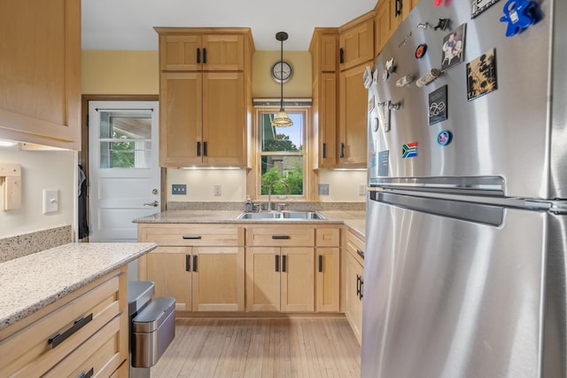 1441 Simpson St, Saint Paul, MN 55108 - kitchen with freestanding refrigerator, light wood finished floors, hanging light fixtures, and light brown cabinetry