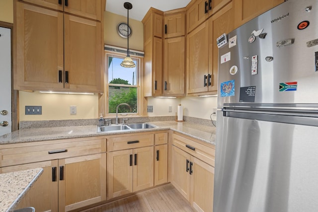 1441 Simpson St, Saint Paul, MN 55108 - kitchen with freestanding refrigerator, light wood-type flooring, pendant lighting, light stone countertops, and light brown cabinets