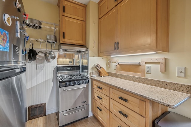 1441 Simpson St, Saint Paul, MN 55108 - kitchen featuring stainless steel appliances, exhaust hood, light wood-style floors, and light stone counters