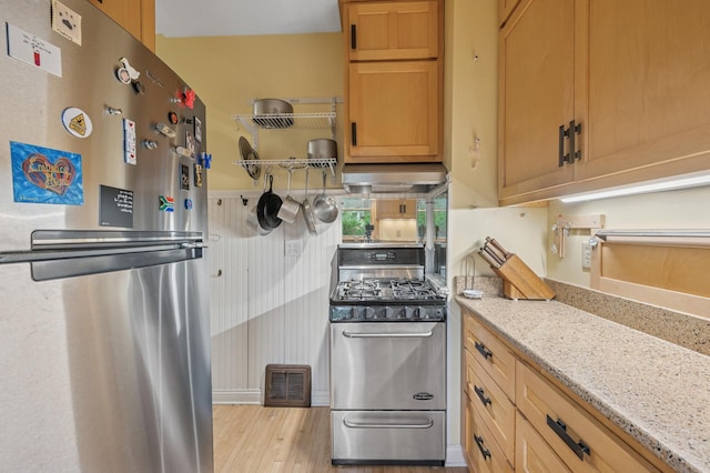 1441 Simpson St, Saint Paul, MN 55108 - kitchen featuring stainless steel appliances, range hood, light stone counters, and light wood-style floors