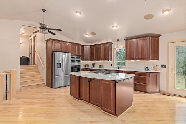 4480 253rd Ave NW, Isanti, MN 55040 - kitchen featuring stainless steel appliances, light wood-type flooring, a ceiling fan, a kitchen island, and lofted ceiling