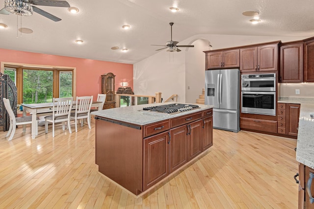 4480 253rd Ave NW, Isanti, MN 55040 - kitchen featuring appliances with stainless steel finishes, a ceiling fan, vaulted ceiling, and light wood-style flooring