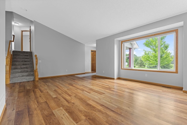 18358 Jenkins St NE, East Bethel, MN 55011 - unfurnished living room featuring light wood-style floors, stairway, and baseboards