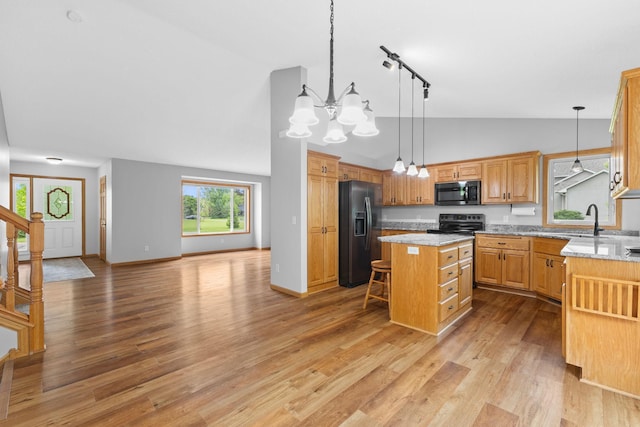 18358 Jenkins St NE, East Bethel, MN 55011 - kitchen with black appliances, a chandelier, a kitchen island, a sink, and light wood finished floors