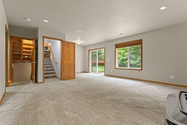 18358 Jenkins St NE, East Bethel, MN 55011 - unfurnished living room featuring stairway, light colored carpet, baseboards, recessed lighting, and a textured ceiling