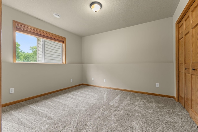 18358 Jenkins St NE, East Bethel, MN 55011 - unfurnished bedroom with carpet, baseboards, a closet, and a textured ceiling