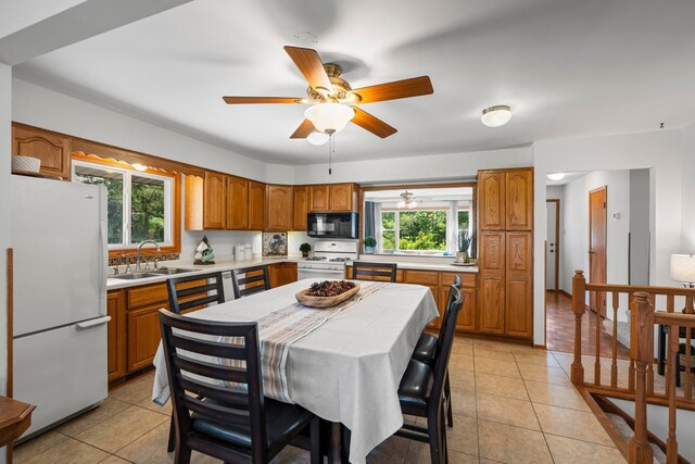 8170 113th St S, Cottage Grove, MN 55016 - kitchen with white appliances, a sink, brown cabinets, light tile patterned floors, and ceiling fan