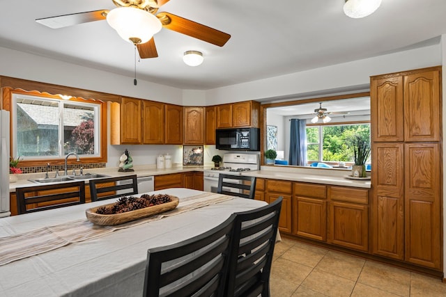 8170 113th St S, Cottage Grove, MN 55016 - kitchen featuring white appliances, brown cabinetry, a sink, and light countertops