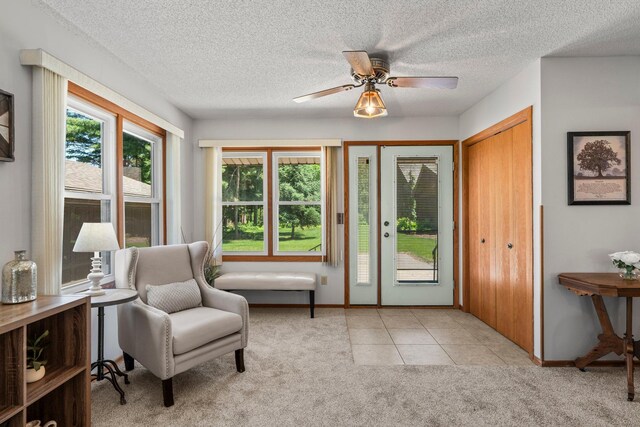 8170 113th St S, Cottage Grove, MN 55016 - living area featuring light colored carpet, baseboards, ceiling fan, a textured ceiling, and light tile patterned flooring