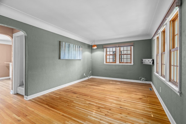 5749 Pleasant Ave S, Minneapolis, MN 55419 - spare room featuring hardwood / wood-style flooring, crown molding, a textured wall, arched walkways, and baseboards
