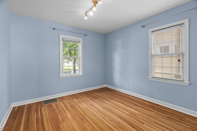 5749 Pleasant Ave S, Minneapolis, MN 55419 - unfurnished room with baseboards, light wood-style floors, and rail lighting
