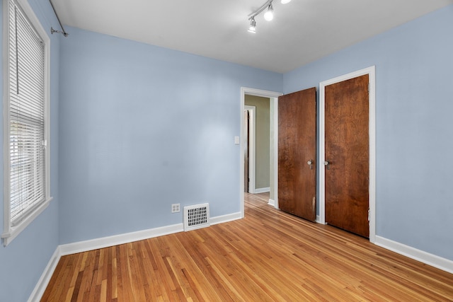 5749 Pleasant Ave S, Minneapolis, MN 55419 - unfurnished bedroom featuring baseboards, light wood-style flooring, multiple windows, and a closet