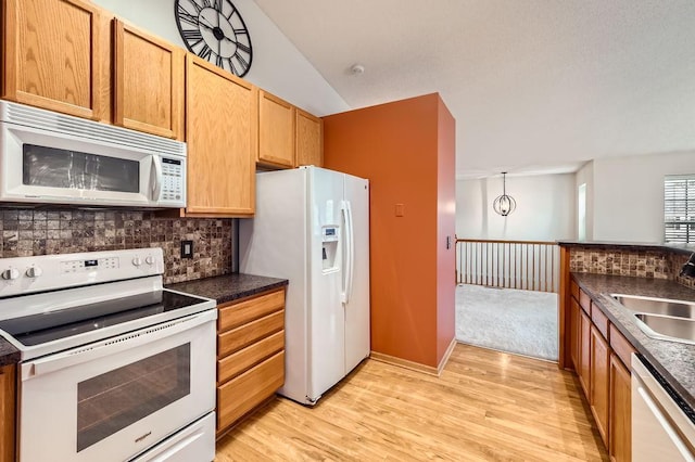 1059 Providence Dr, Shakopee, MN 55379 - kitchen with white appliances, a sink, decorative backsplash, dark countertops, and lofted ceiling