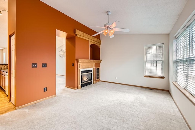 1059 Providence Dr, Shakopee, MN 55379 - unfurnished living room featuring ceiling fan, light carpet, a fireplace with flush hearth, and baseboards