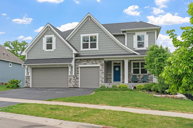 7137 61st St S, Cottage Grove, MN 55016 - craftsman inspired home with an attached garage, driveway, stone siding, covered porch, and a front lawn