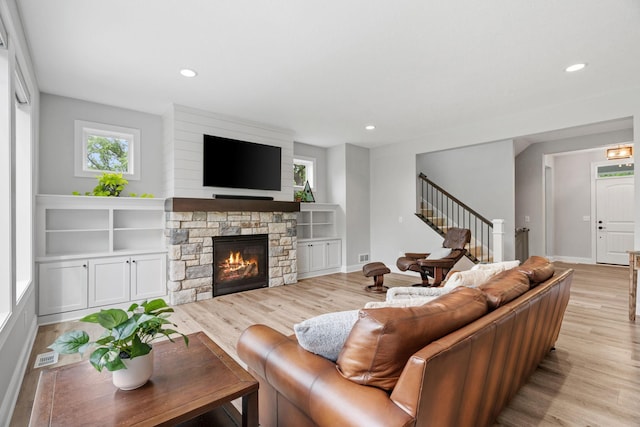 7137 61st St S, Cottage Grove, MN 55016 - living room featuring stairs, light wood-type flooring, recessed lighting, a stone fireplace, and baseboards