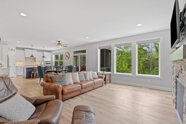 7137 61st St S, Cottage Grove, MN 55016 - living area with a fireplace, ceiling fan, recessed lighting, light wood-type flooring, and baseboards