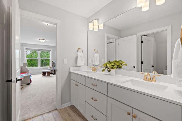 7137 61st St S, Cottage Grove, MN 55016 - full bath featuring double vanity, toilet, wood finished floors, and baseboards