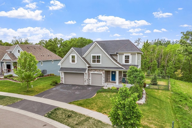 7137 61st St S, Cottage Grove, MN 55016 - view of front of house featuring driveway, a garage, stone siding, cooling unit, and a porch