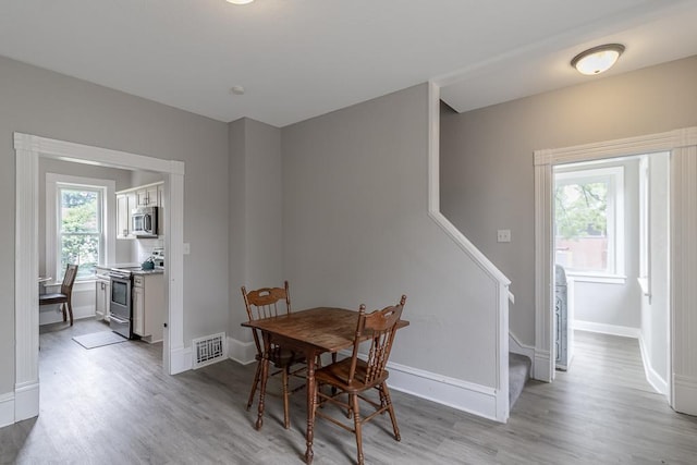 202 Adams St, Arlington, MN 55307 - dining area with light wood-type flooring, stairway, and baseboards