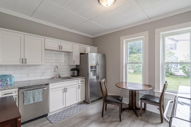 202 Adams St, Arlington, MN 55307 - kitchen with stainless steel appliances, backsplash, white cabinetry, light wood-type flooring, and ornamental molding