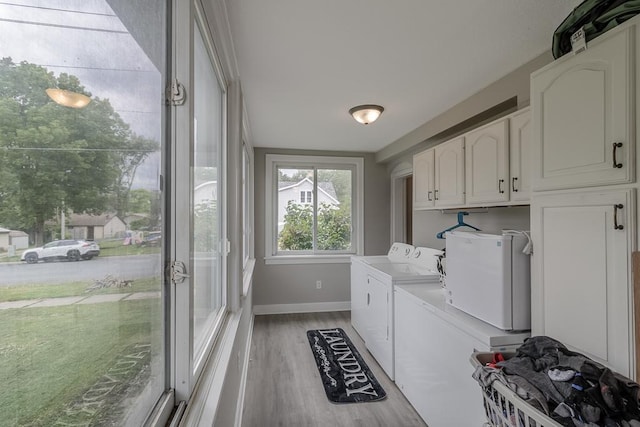 202 Adams St, Arlington, MN 55307 - laundry room with washing machine and dryer, cabinet space, baseboards, and light wood finished floors