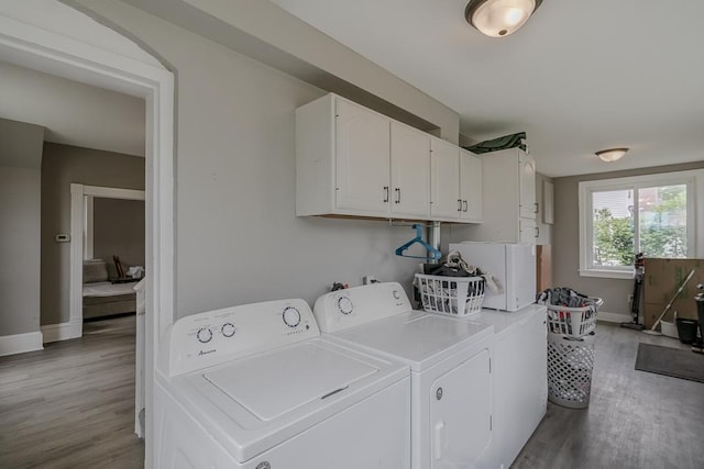 202 Adams St, Arlington, MN 55307 - laundry room featuring cabinet space, separate washer and dryer, light wood-type flooring, and baseboards