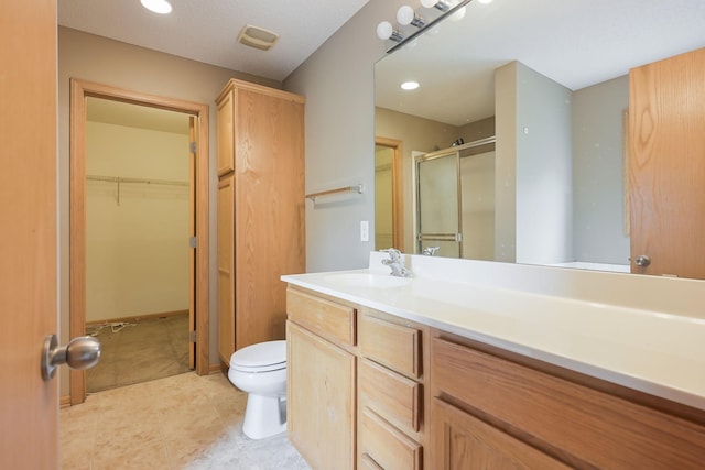 3003 Cutters Grove Ave, Anoka, MN 55303 - full bath with a stall shower, toilet, vanity, a spacious closet, and tile patterned flooring