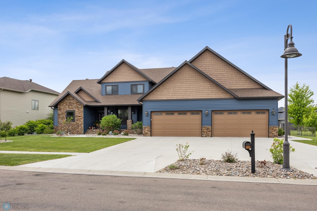 4375 Lee Ln S, Fargo, ND 58104 - craftsman house with a front lawn, stone siding, a garage, concrete driveway, and a shingled roof
