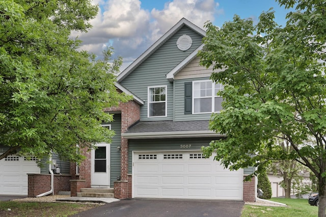 3007 Cutters Grove Ave, Anoka, MN 55303 - view of front of home featuring asphalt driveway, an attached garage, brick siding, and entry steps