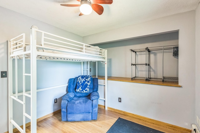 816 Glenbrook Ave N, Oakdale, MN 55128 - unfurnished bedroom featuring wood finished floors, a ceiling fan, and a baseboard heating unit