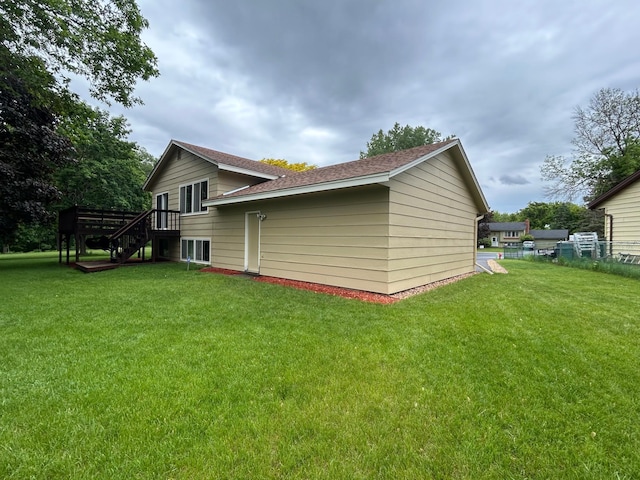3476 116th Ln NW, Coon Rapids, MN 55433 - view of home's exterior featuring stairway, a yard, a wooden deck, and a shingled roof