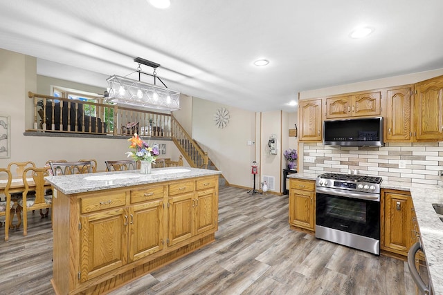 843 Northdale Blvd NW, Coon Rapids, MN 55448 - kitchen featuring stainless steel appliances, light wood-type flooring, tasteful backsplash, a kitchen island, and recessed lighting