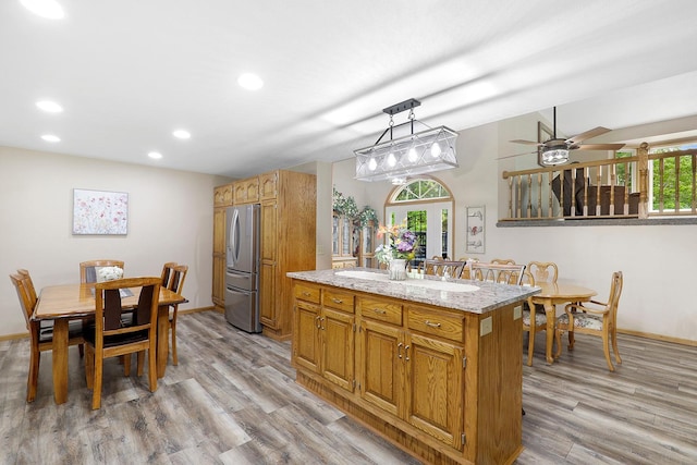 843 Northdale Blvd NW, Coon Rapids, MN 55448 - kitchen featuring freestanding refrigerator, light wood-type flooring, recessed lighting, baseboards, and a center island