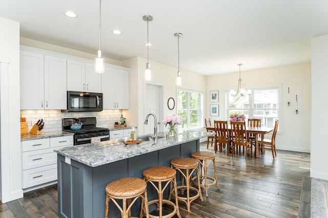 927 Southwell Enclave NE, Byron, MN 55920 - kitchen featuring black appliances, backsplash, light stone counters, white cabinetry, and a breakfast bar
