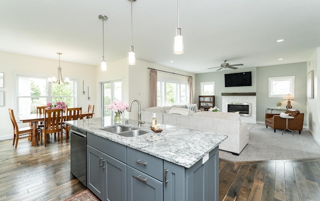 927 Southwell Enclave NE, Byron, MN 55920 - kitchen featuring a sink, dishwasher, gray cabinetry, ceiling fan, and a glass covered fireplace